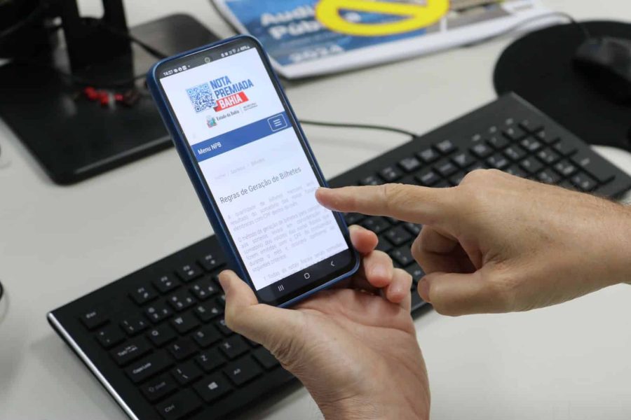 Pessoa consultando os bilhetes da Nota Premiada Bahia