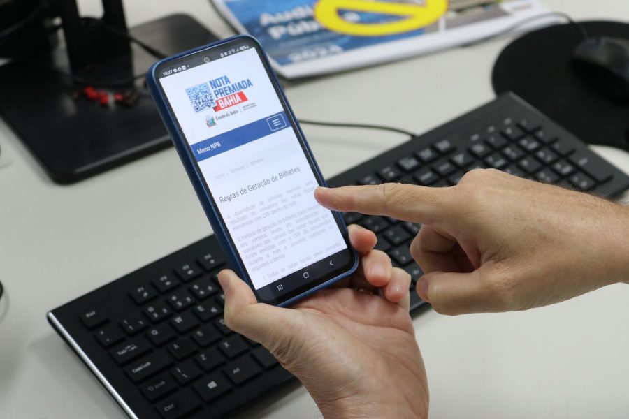 Foto de celular com tela da campanha Nota Premiada Bahia